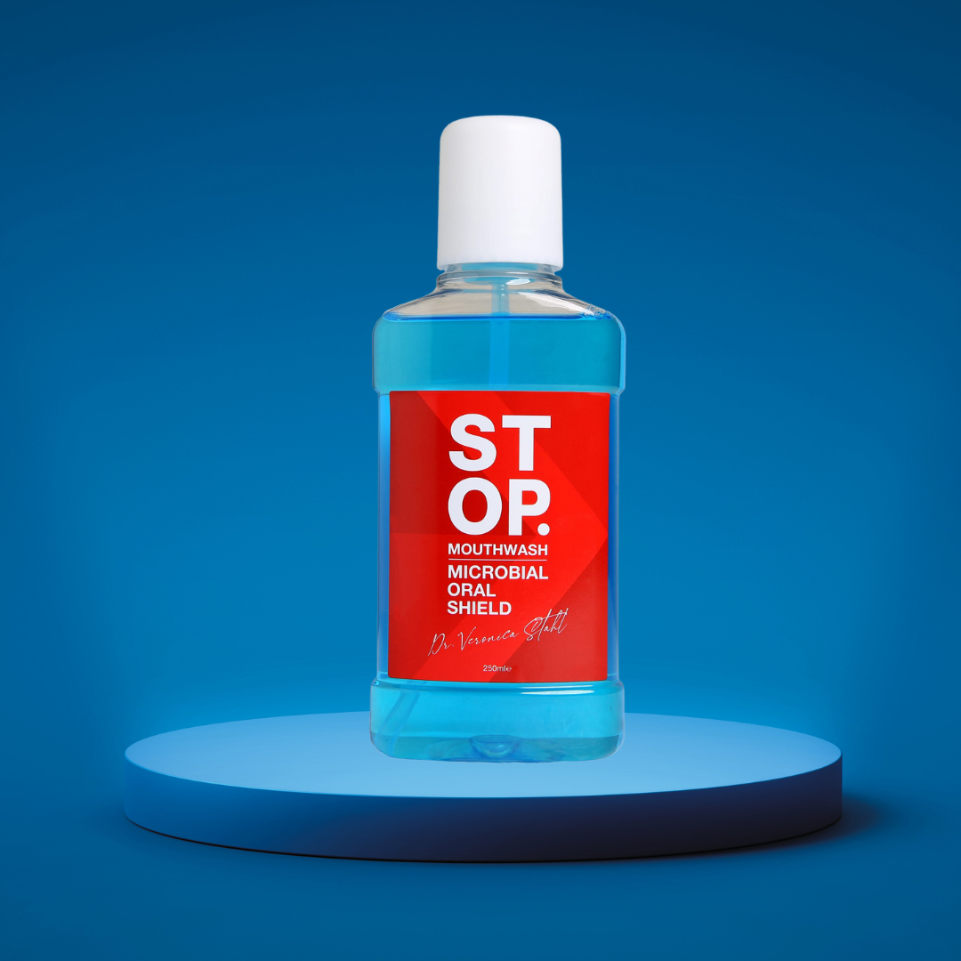 Close-up of 'STOP' mouthwash bottle with 'Microbial Oral Shield' label, signed by Dr. Veronica Stahl, prominently displayed on a lighted blue platform against a vibrant blue background.