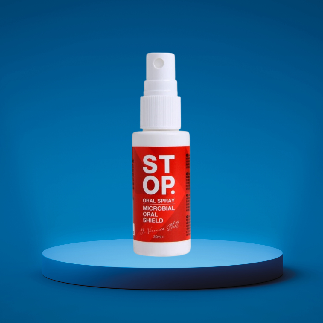 White spray bottle labeled 'STOP' showcasing 'Oral Spray with Microbial Oral Shield' feature, created by Dr. Veronica Stahl, placed on a blue illuminated platform with a vivid blue background.